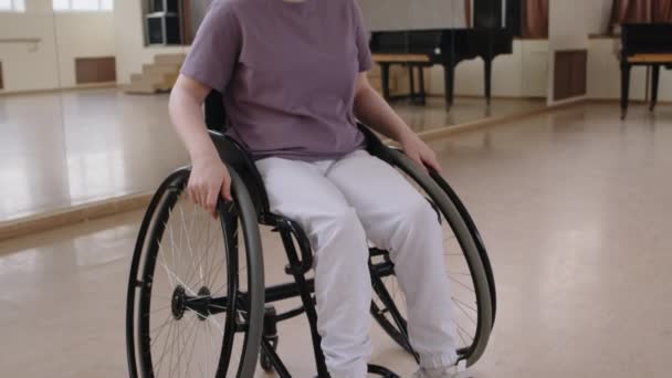 스튜디오에서 미소와 카메라를 휠체어에서 소녀의 초상화 기울이기 — 비디오