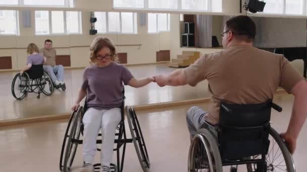 在演播室排练时 坐在轮椅上的年轻夫妇在镜子前练习舞伴 — 图库视频影像