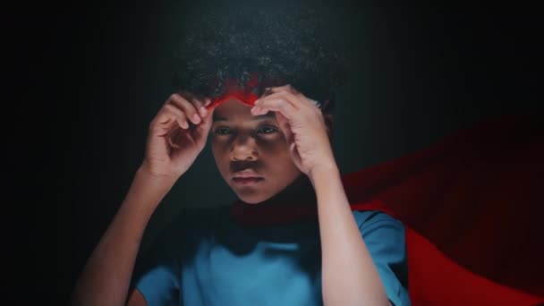 Portret Małego Afroamerykanina Czerwonej Pelerynie Zakładającego Maskę Superbohatera Twarz Składającego — Wideo stockowe