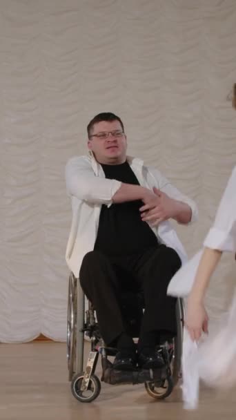坐在轮椅上的男人和舞伴在舞台上用白带表演表现性舞蹈的垂直缩影 — 图库视频影像
