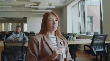 Genç iş kadını açık uzay ofisinde çalışırken bilgisayar konferansı sırasında tartışıyor.