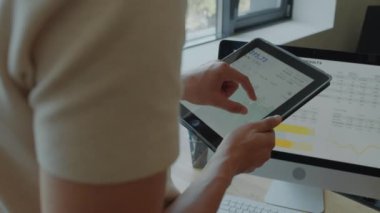 Ofiste iş gününde dijital tablet üzerindeki finansal grafiği yakınlaştıran ve inceleyen iş adamlarının ellerini kapat