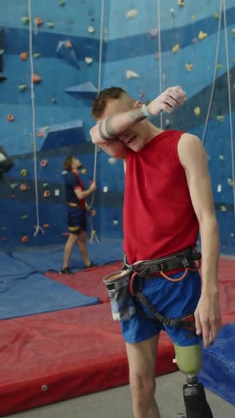 在攀爬馆训练后 用美腿擦拭额头上的汗水 并在智能吸盘上检查健身追踪应用程序的运动员的垂直照片 — 图库视频影像