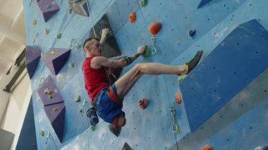 Spor salonunda duvara tırmanırken alt bacak sakatlığı olan güçlü bir sporcunun görüntüsü