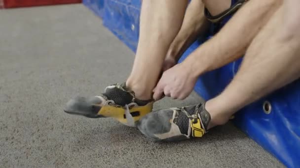 Schiefe Aufnahme Eines Männlichen Athleten Sportbekleidung Der Kletterschuhe Anzieht Während — Stockvideo