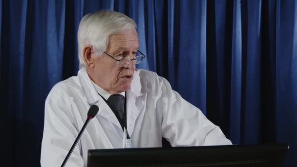 Старший Лікар Білого Пальто Стоїть Лекції Мікрофоном Звітує Про Глобальні — стокове відео