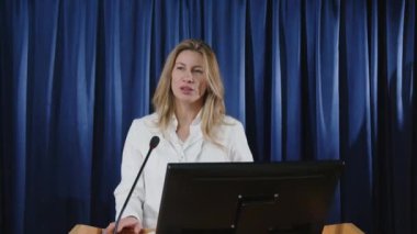 Kürsüde kürsüde duran ve basın toplantısı sırasında gazetecilerin önünde mikrofonla konuşan kadın sağlık görevlisi