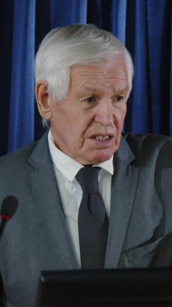 Pionowe Ujęcie Starszego Urzędnika Rządowego Siwymi Włosami Formalnym Garniturze Przemawiającego — Wideo stockowe