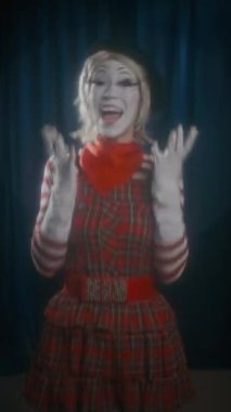 Sahnede dikilen mutlu kadın pandomimci ressamın dikey çekimi, heyecanlanıyor ve komedi gösterisi sırasında elleri kalçasında poz veriyor.