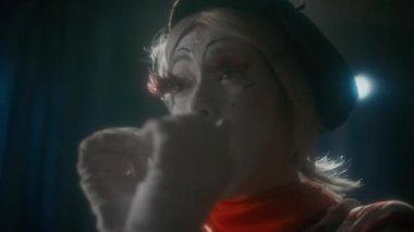 Kadın pandomim sanatçısı sahnede komedi gösterilerinde aşk duygusunu oynarken elini, hava öpücüğünü ve kucaklamasını gösteriyor.