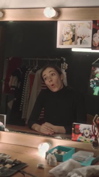 年轻女演员坐在剧场更衣室的虚荣桌前 在镜子前表演面部表情和情感的垂直镜头 — 图库视频影像