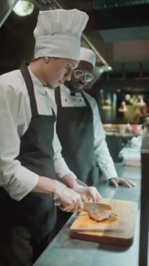 Lokanta mutfağında aşçılık stajı yaparken çırak olarak çıraklık yaptığı ahşap tahtadan biftekleri keserken çekilmiş dikey bir fotoğraf.