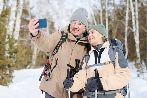 一对中年夫妇穿着运动服 背着背包在森林里徒步旅行时拍下了自己的照片 图库照片