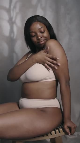 스튜디오에 부드럽게 그녀의 피부를 속옷에 구부러진 아프리카계 미국인 여성의 — 비디오