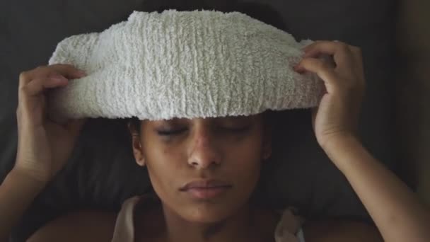 ベッドに横たわり 発熱している間に濡れたタオルを額に塗りつぶした病気の女の子のトップダウンショット — ストック動画
