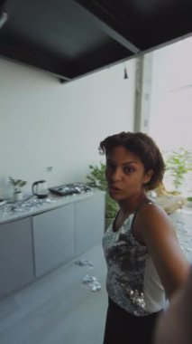 Parti kıyafeti giymiş genç bir kızın dağınık oturma odasında yürürken, sonra da koltukta oturup dün geceki partiyi kameraya çekerken ya da video kaydında...