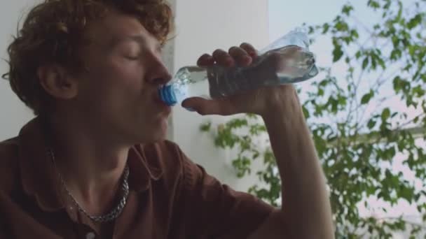 Fiatal Másnapos Férfi Ivóvíz Sms Ezés Mobiltelefon Dőljön Vissza Kanapén — Stock videók