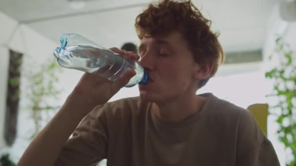 Fiatal Szomjas Srác Iszik Vizet Üvegből Miközben Szenved Rossz Másnaposság — Stock videók