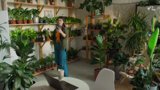 Kompletní Záběr Běru Bělošky Manažerky Obchodu Chytrým Telefonem Demonstrující Květináče — Stock video