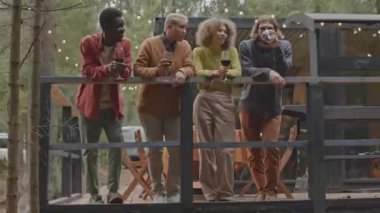 Şarap içen, doğaya bakan ve çene çalan genç arkadaşlardan oluşan bir grup. Ormanın terasındaki telli ışıklarla süslenmiş bir kulübede duruyorlar.