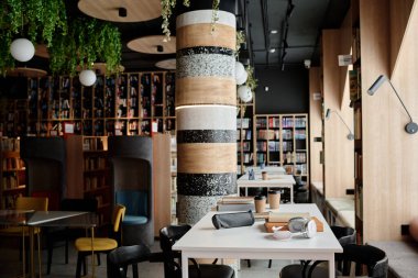 Gündüz vakti modern üniversite kütüphanesinin içini kitaplık, kitaplık ve tablolarla dolduran hiç kimse çekilemez.