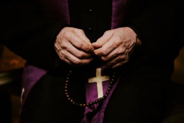Dua ederken elinde tespih tutan tanınmayan kıdemli papazın elleri, boşluğu kopyalayın.