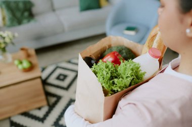 Hemşirenin tuttuğu poşet dolusu sağlıklı yiyeceğin fotoğrafını çek.