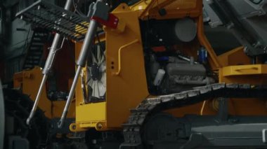 Endüstriyel fabrika üretim makinelerinde sürekli rayları olan buldozer çekimini yukarı kaldır