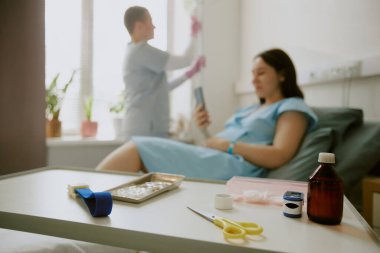 Üzerinde ilaç kutusu, nabız ölçer ve tıbbi ekipman olan beyaz tıbbi tablonun orta ölçekte kapatılması.