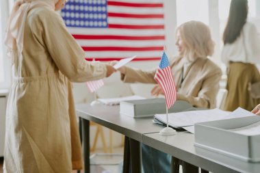 Seçim bölgesinde çalışan ve oy kullanan farklı kadınların ABD bayrağı çekimleri üzerine seçici odak noktası, boşluğu kopyala