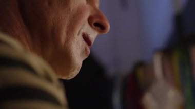 Olgun beyaz erkek palyaçonun yüz profiline yakın çekim sirk gösterisine hazırlanıyor, eklemli ve eklemli bir şekilde kaslarını ısıtıyor.