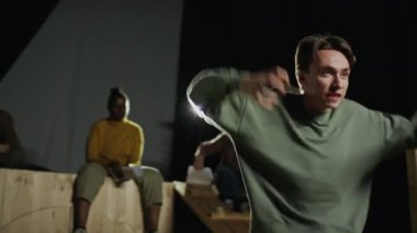 Genç duygusal aktör prova sırasında sahnede dramatik bir performans sergiliyor.