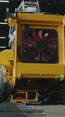 Endüstriyel fabrikadaki üretim sırasında sarı traktör veya dozer dikey eğim.