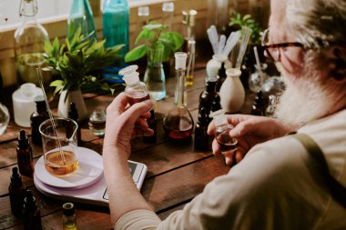 Olgun parfümcünün çalışma masasında oturup kristal şişelerdeki iki aromatik karamel ve konyak esansını karşılaştırdığı omuz üstünden.