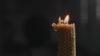 Kilisenin karanlık arka planında hiç insan olmadan yanan mumu yakın çekim yap.