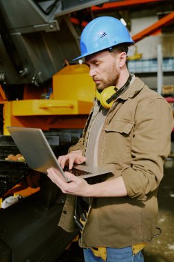 Kafkas teknisyeninin iş yerindeki makine üretim fabrikasında bilgisayarında daktilo kullanırken orta boy dikey görüntüsü.