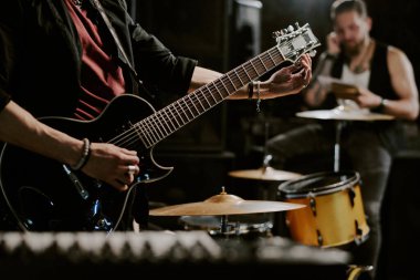Grupta çalan tanınmamış rock müzisyeni elektro gitar çalmaya hazırlanıyor.