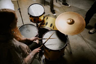 Tanınmayan bayan rock müzisyeninin yüksek açılı görüntüsü davul çalma, kopyalama alanı