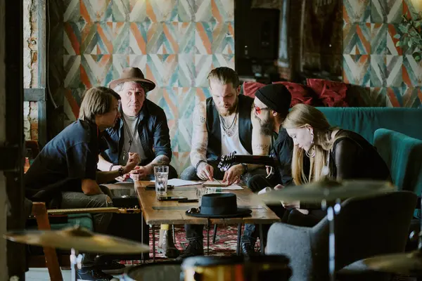 stock image Modern gen X grunge music band sitting in living room in abandoned house writing songs for new album