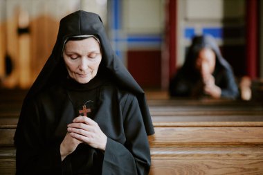 Seçici odak noktası, dindar Katolik rahibenin ellerinde ahşap haç tutarak Tanrı 'ya uzayı kopyalaması için dua etmesi.