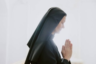 Kafkas Katolik rahibesinin Tanrı 'ya dua edişinin beyaz arkaplan, kopyalama alanı.