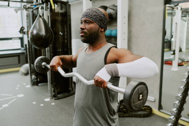 Young African American man doing high pull to make his shoulder muscle stronger clipart