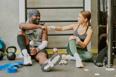 Afrika kökenli Amerikalı erkek ve beyaz kadın esneme sırasında yumruk tokuşturuyorlar.