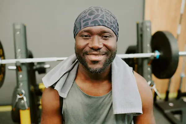 stock image African American man sitting on bench after workout, he smiling and looking at camera