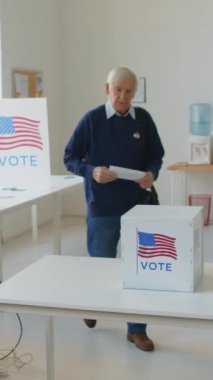Kafkasyalı yaşlı bir adamın oy pusulasında oy pusulasını bırakıp giderken dikey çekimi.