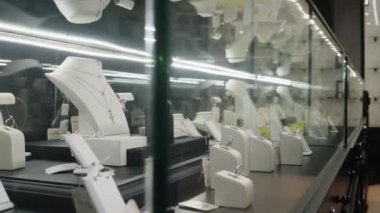 Premium butikte vurgulanmış minimalist cam vitrinlerde sergilenen kaliteli mücevherlere yakın çekim yapan insanlar yok.