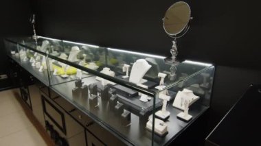 Prestijli bir butik tarafından sunulan zarif cam vitrinde sergilenen yüksek kaliteli özel mücevher parçalarından çekilen hiç kimse yok.