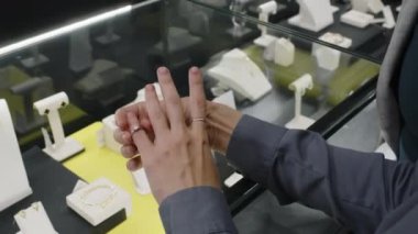 Yüzük deneyen ve butikte sergilenen kaliteli mücevher çeşitlerinden birini seçen iki tanınmayan çok ırklı kadın müşterinin yakın çekimleri.