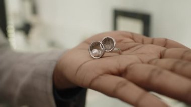Çok kaliteli mücevher mağazasında, avuç içine beyaz inci işlemeli özel yapım bir yüzük takan tanınmamış siyahi bir kadının yakın çekimi.