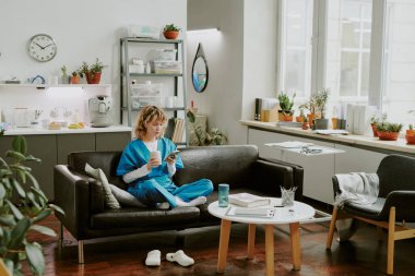 Kafkasyalı genç hemşire vardiyasından önce kahve molası verip telefonunu kontrol ediyor.